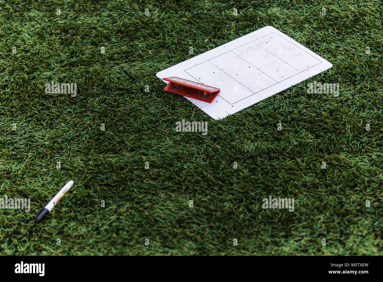 Coach's board and pen on the grass background Stock Photo