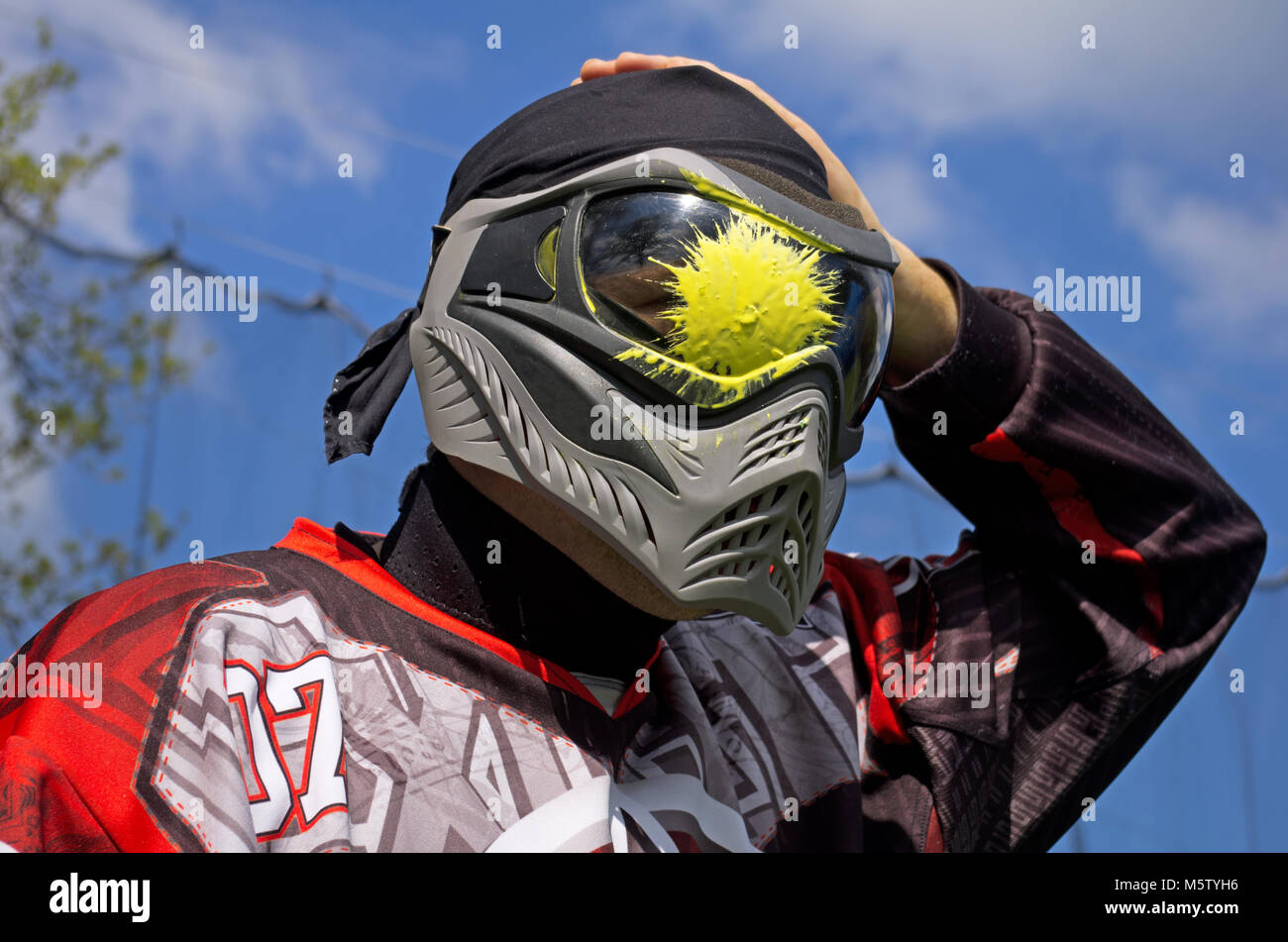 Paintball sport player with head shot by paint spot Stock Photo