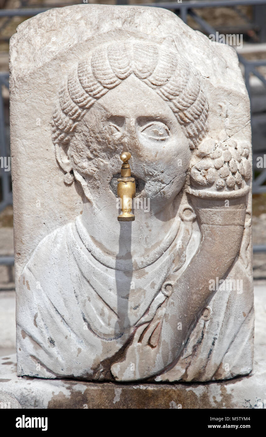 Brass facet stuffed into the mouth of the 2,000- year-old Fountain of Abundance in Pompeii, Italy. Stock Photo