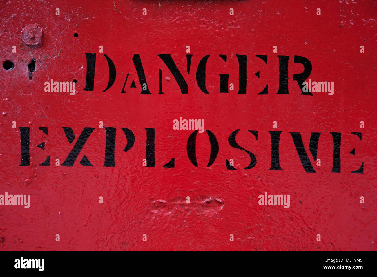 Red warning sign stating 'danger explosives', Dolaucothi Gold Mine, Carmarthenshire, Wales. Stock Photo