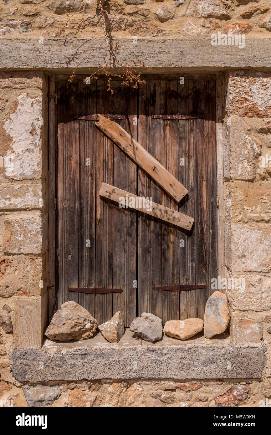 Shuttered and barred old window in a stone wall Stock Photo