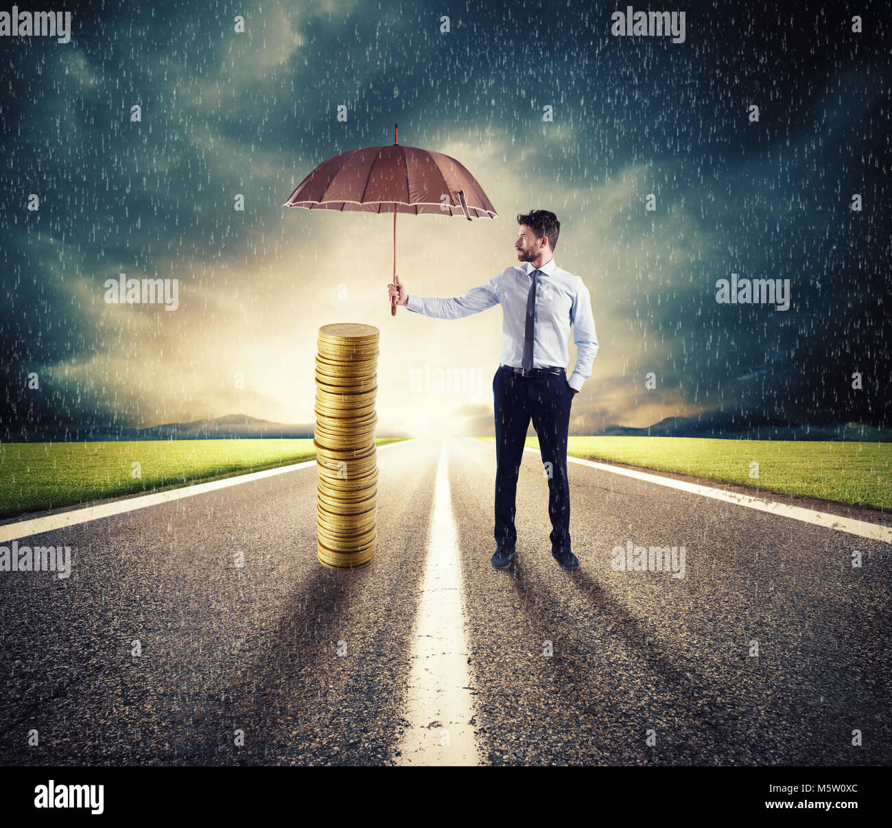 Businessman protects his money savings with umbrella. concept of insurance and money protection Stock Photo