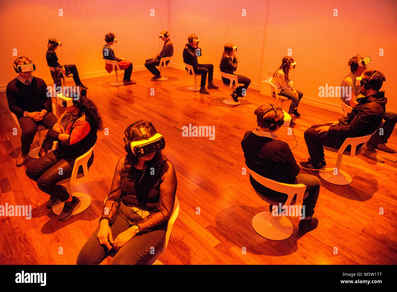 real people use an interactive virtual reality headset and head phones in an art gallery Stock Photo