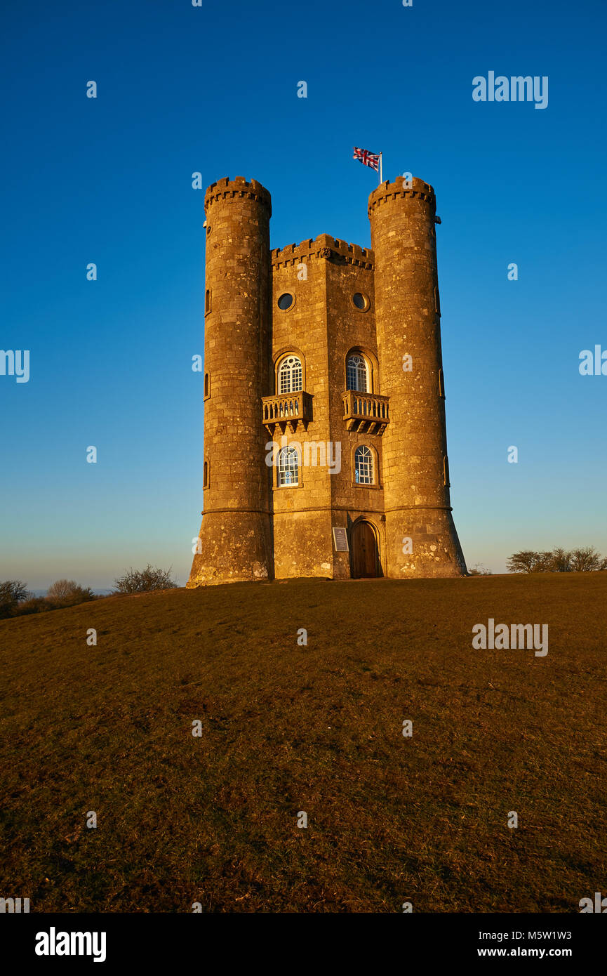 Broadway Tower, set on top of Fish Hill the second highest point in the Cotswolds, set against a clear blue late winter afternoon sky. Stock Photo