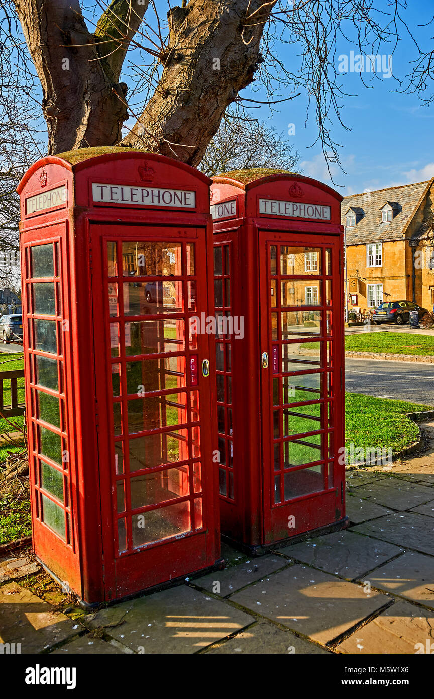 Two iconic red telephone kiosks on the High Street in the Cotswolds town of Broadway. Stock Photo
