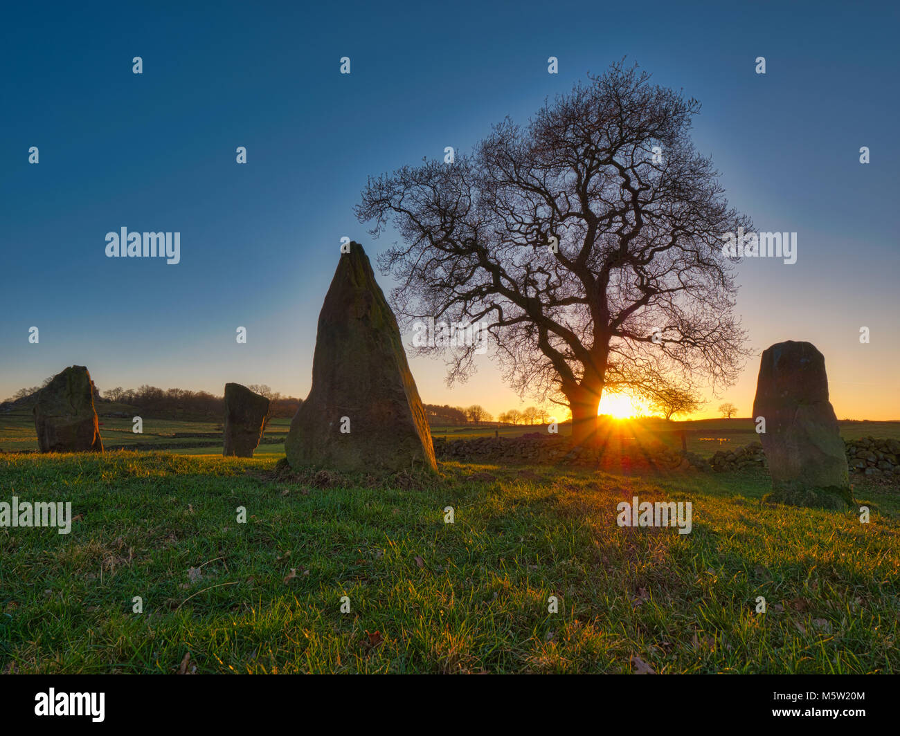 spectacular sunset on a bitterly cold day at The Grey Ladies / Nine Stone Close Stone Circle, Robin Hood's Stride Peak District National Park Stock Photo