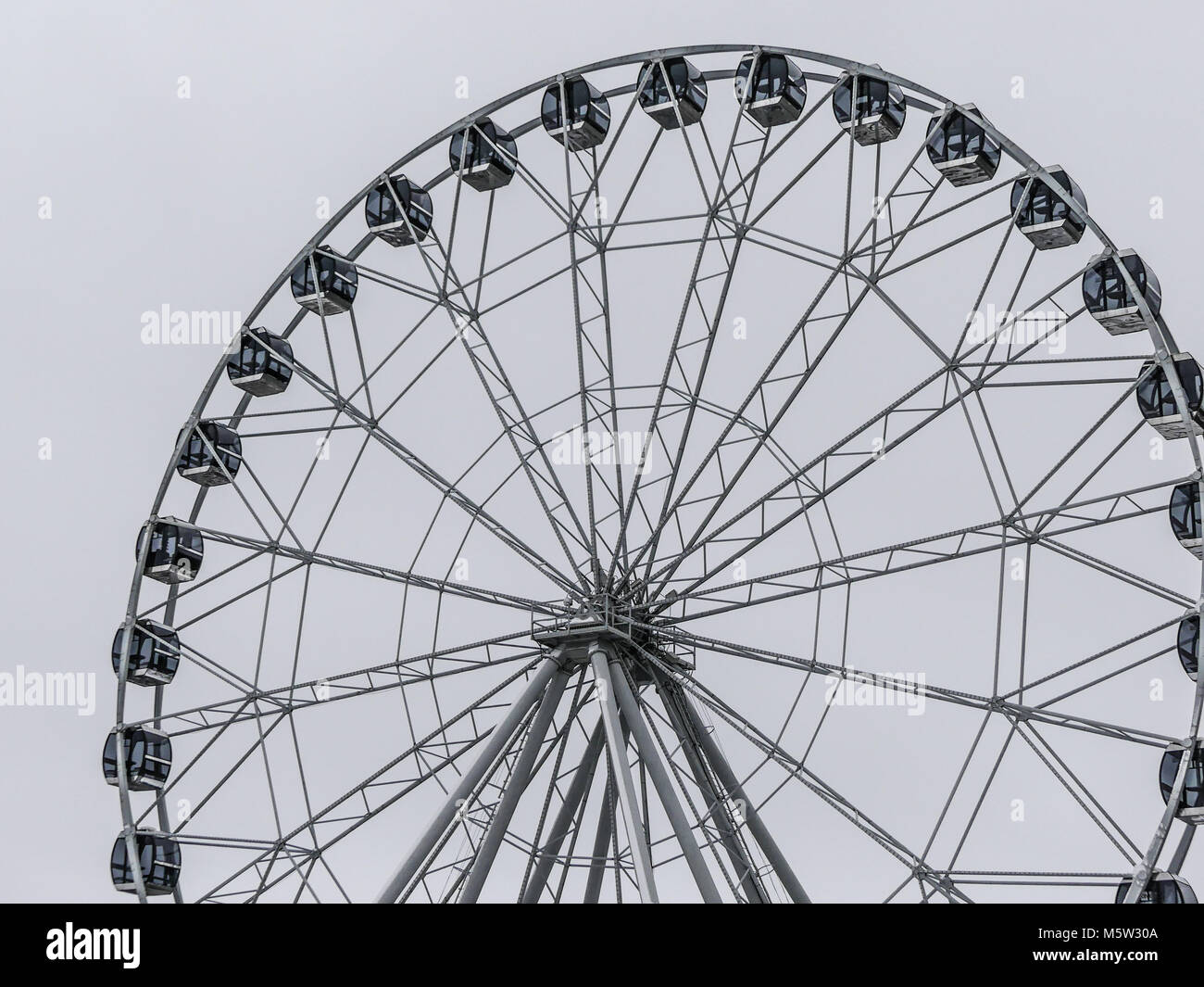 Ferris wheel on light grey sky background Stock Photo
