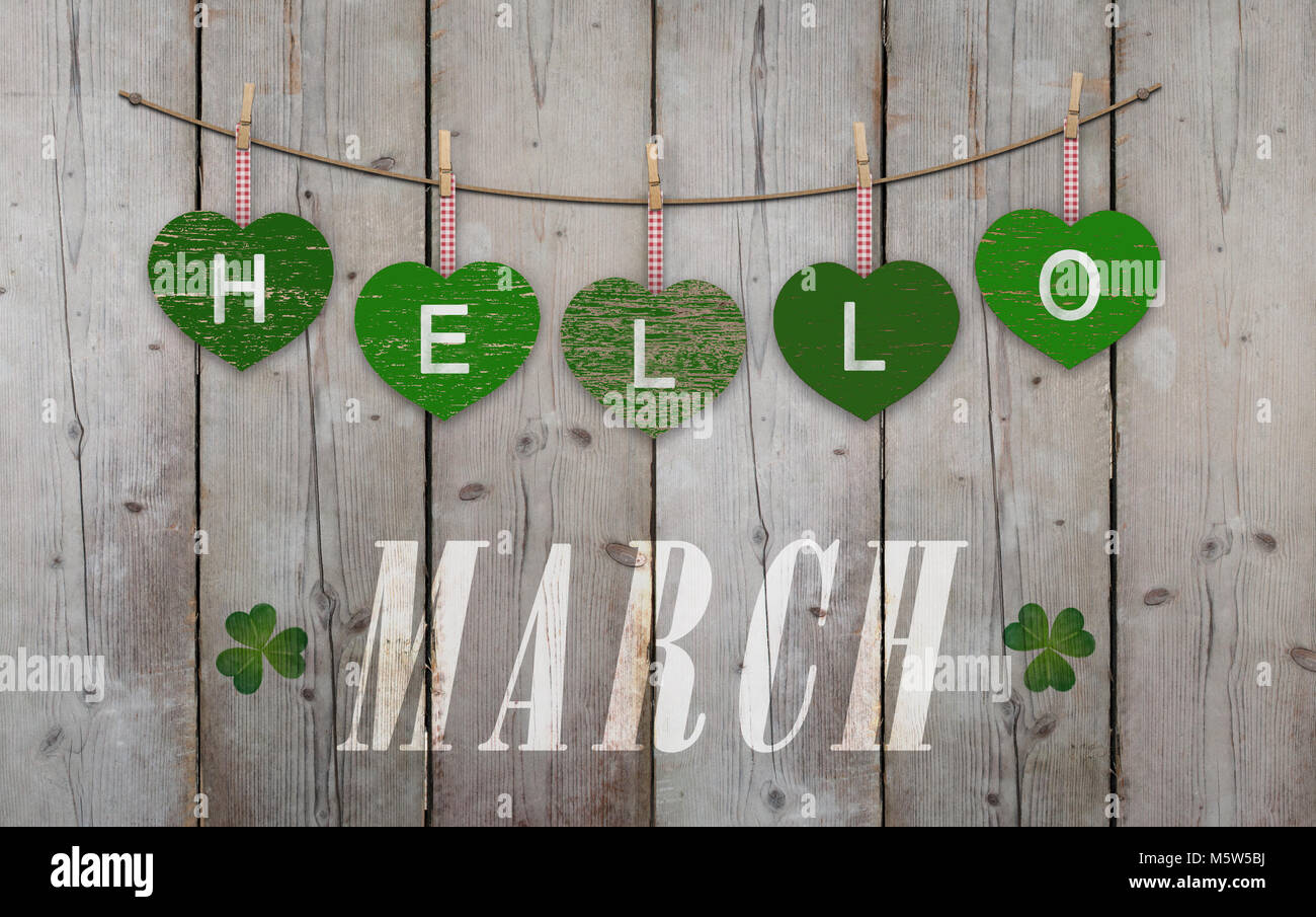 Hello March written on hanging green hearts and weathered wooden ...