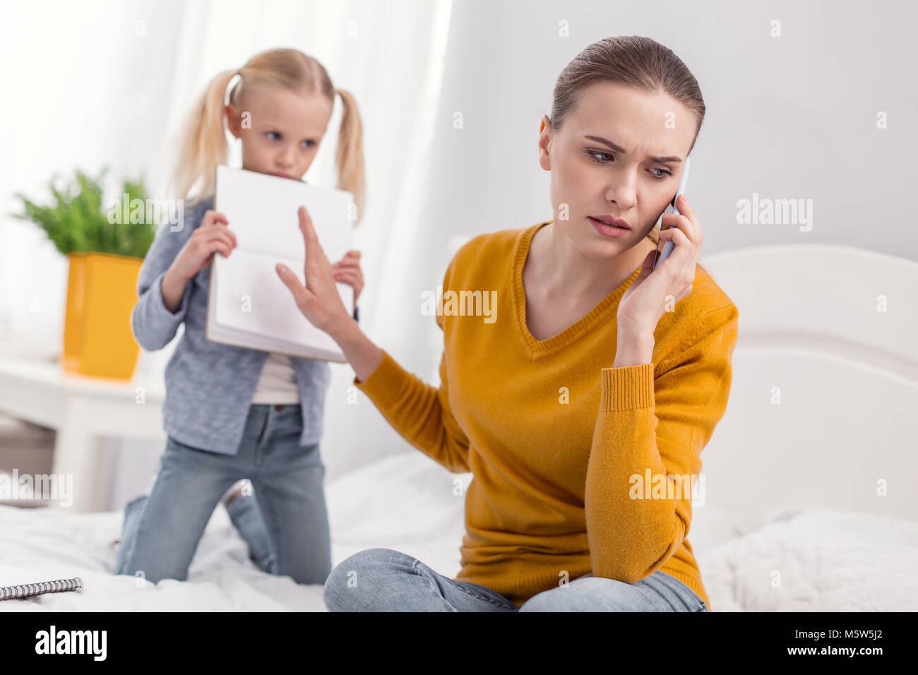 Angry sad mom having no time for daughter Stock Photo