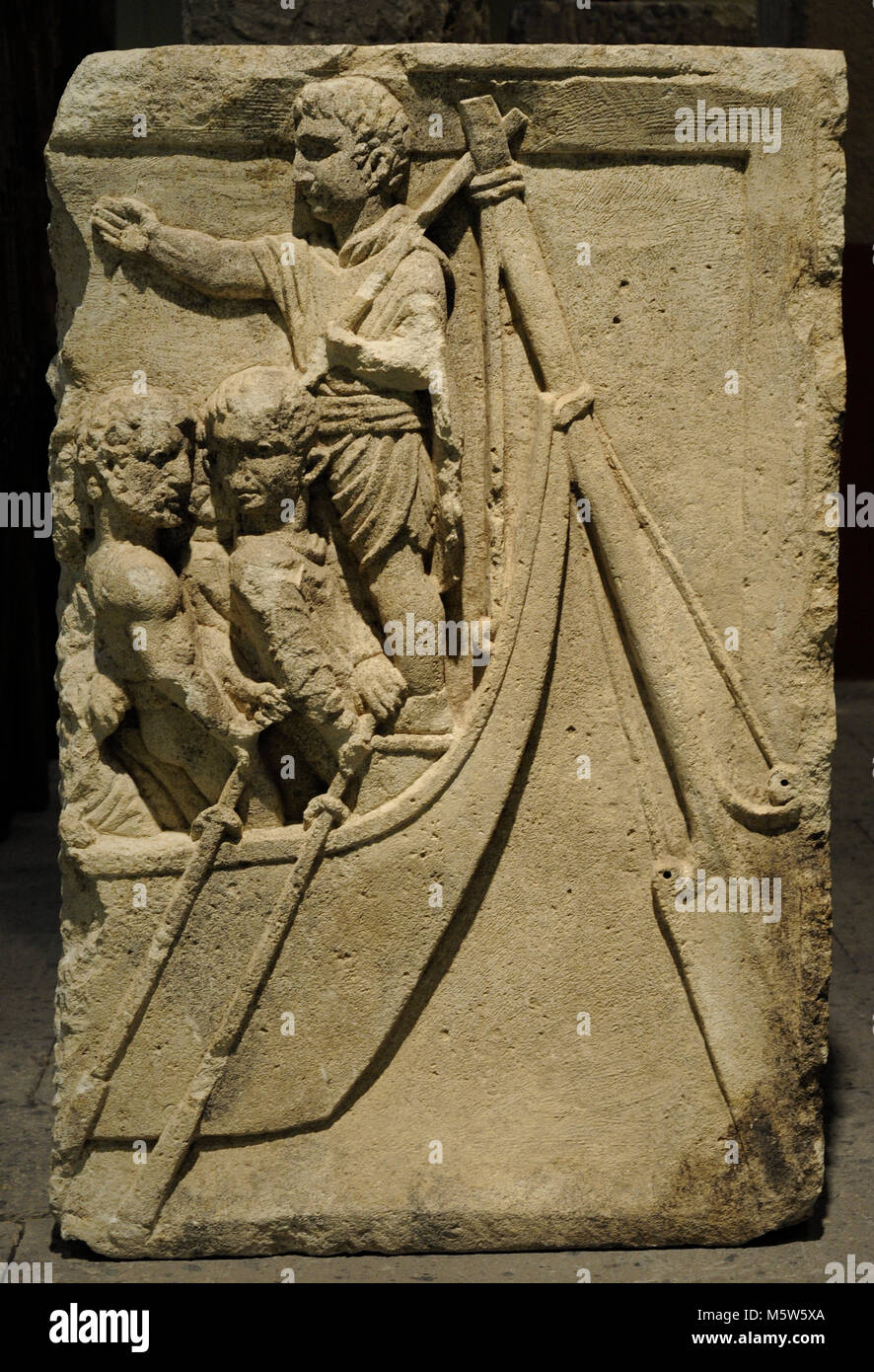 Fragment of a funerary relief. Stern of a ship with the helmsman and the rowers, who by their appearance seems to be barbarians. End of the 1st century. From Cologne, Germany. Roman-Germanic Museum. Cologne. Germany. Stock Photo