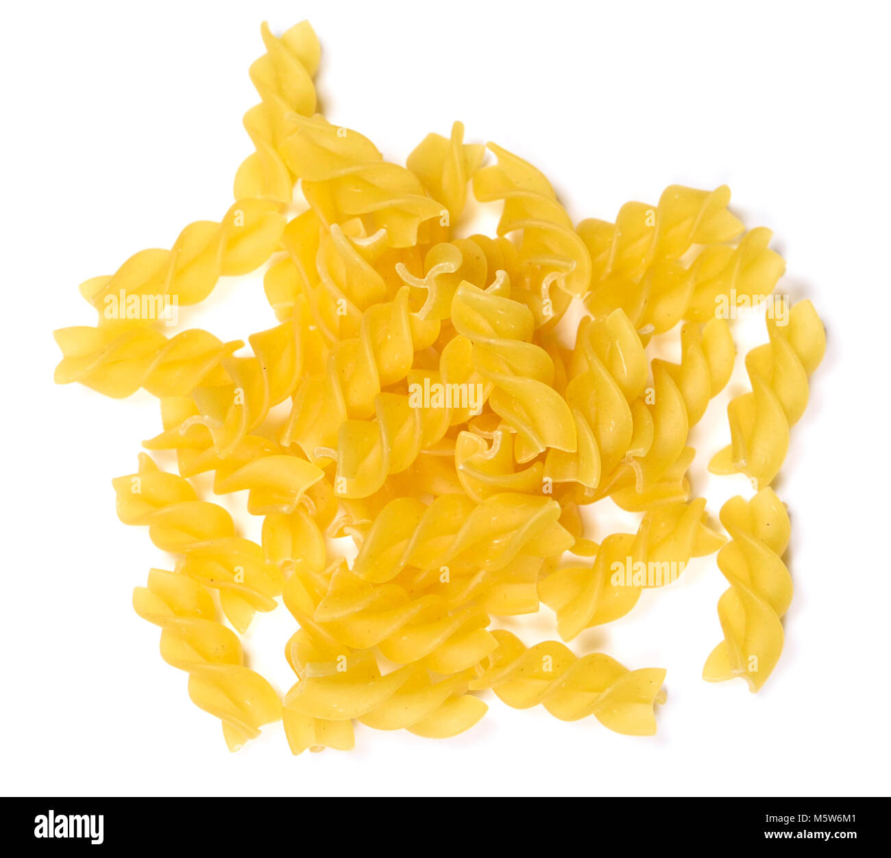 Raw pasta or dry pasta, isolated on white background. Italian pasta, fussili noodles on white with copy space. Cut out food or ingredients. Stock Photo