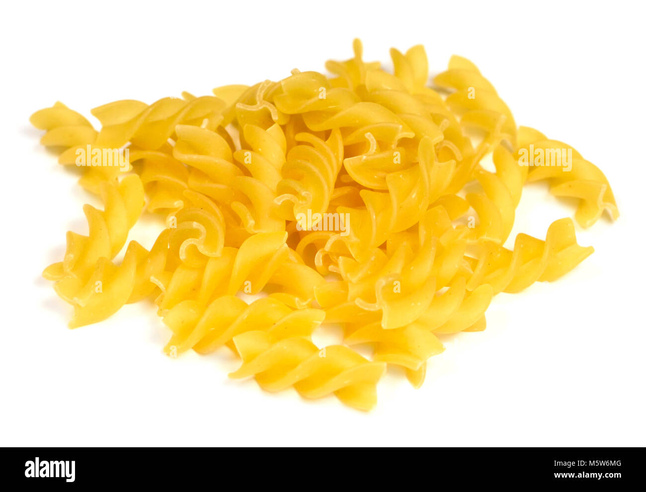 Raw pasta or dry pasta, isolated on white background. Italian pasta, fussili noodles on white with copy space. Cut out food or ingredients. Stock Photo