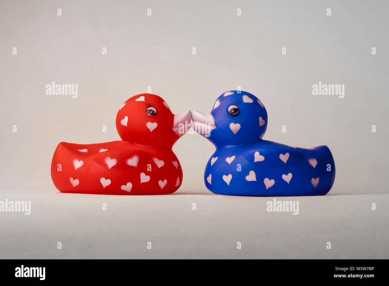 Valentine bath love ducks with hearts on their bodies, kissing on lips Stock Photo