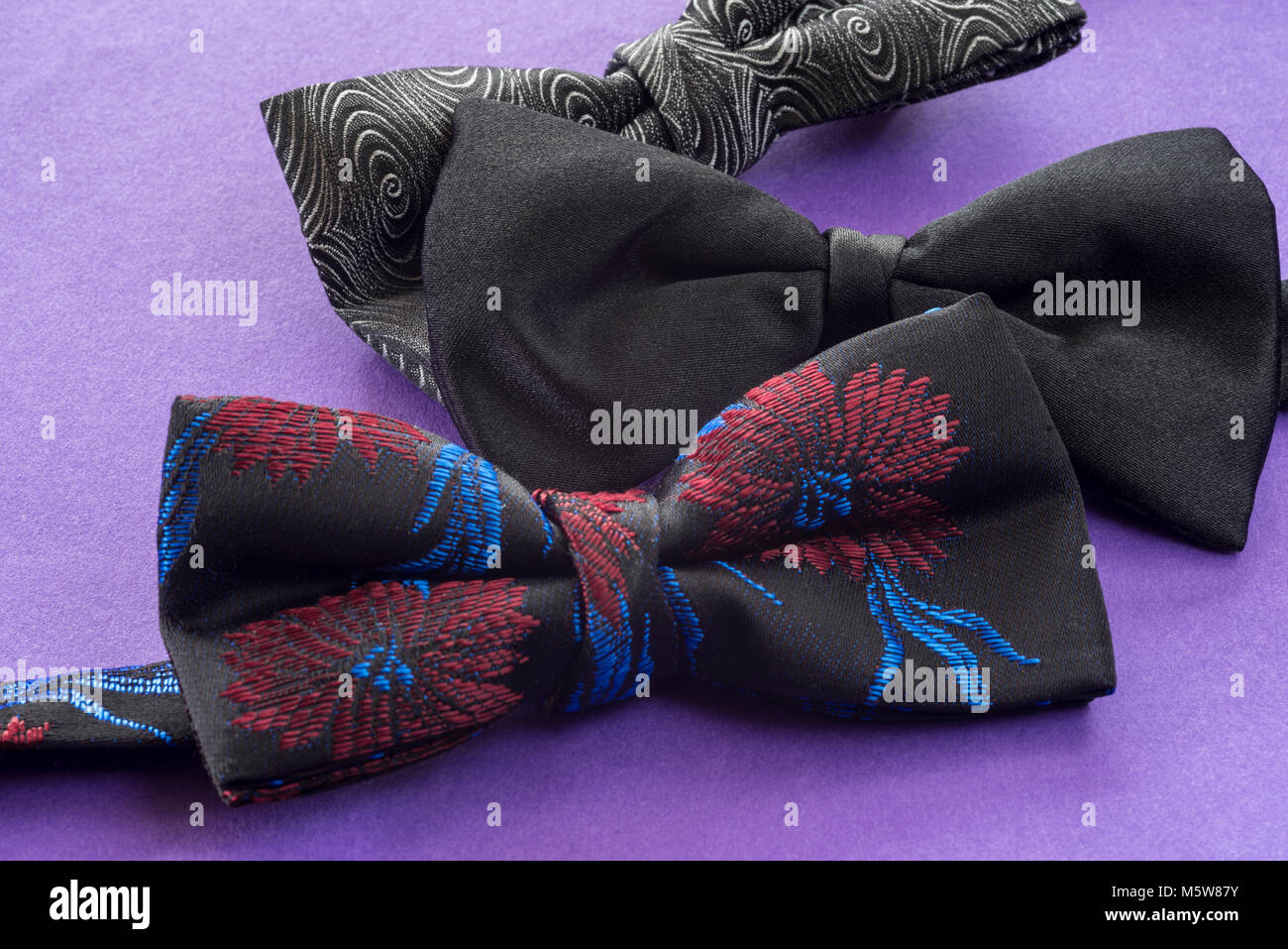 Three bow ties on apurple background. Stock Photo