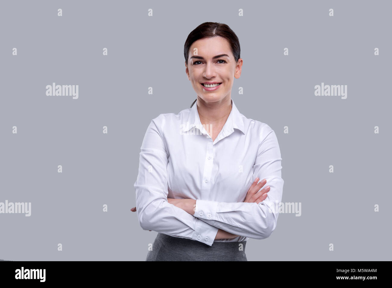 Smiling woman standing with her arms crossed Stock Photo - Alamy