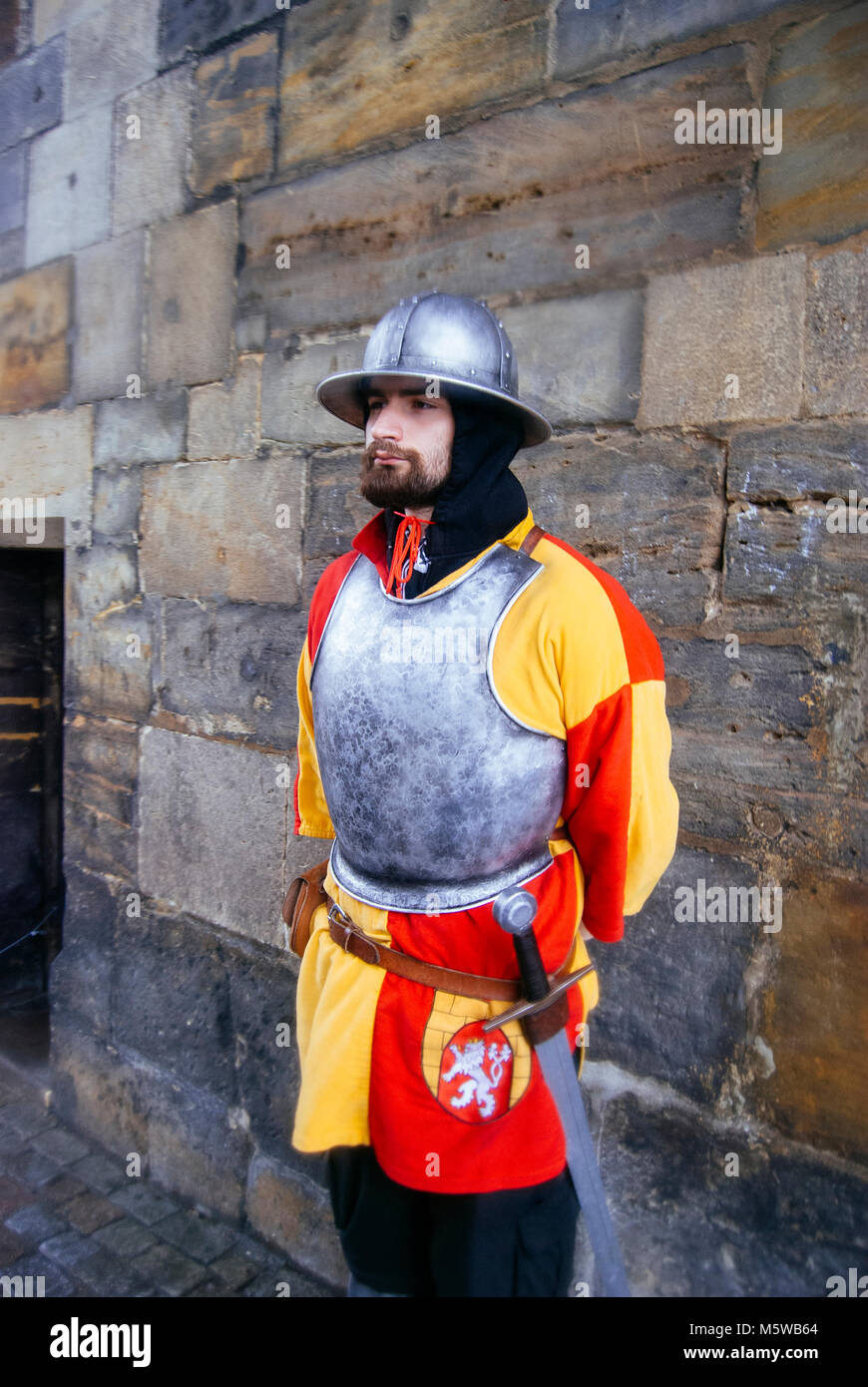 A guard, dressed as a medieval knight (red and yellow colour uniform represents the flag of Prague) at the Powder Tower in Prague, Czech Republic. Stock Photo