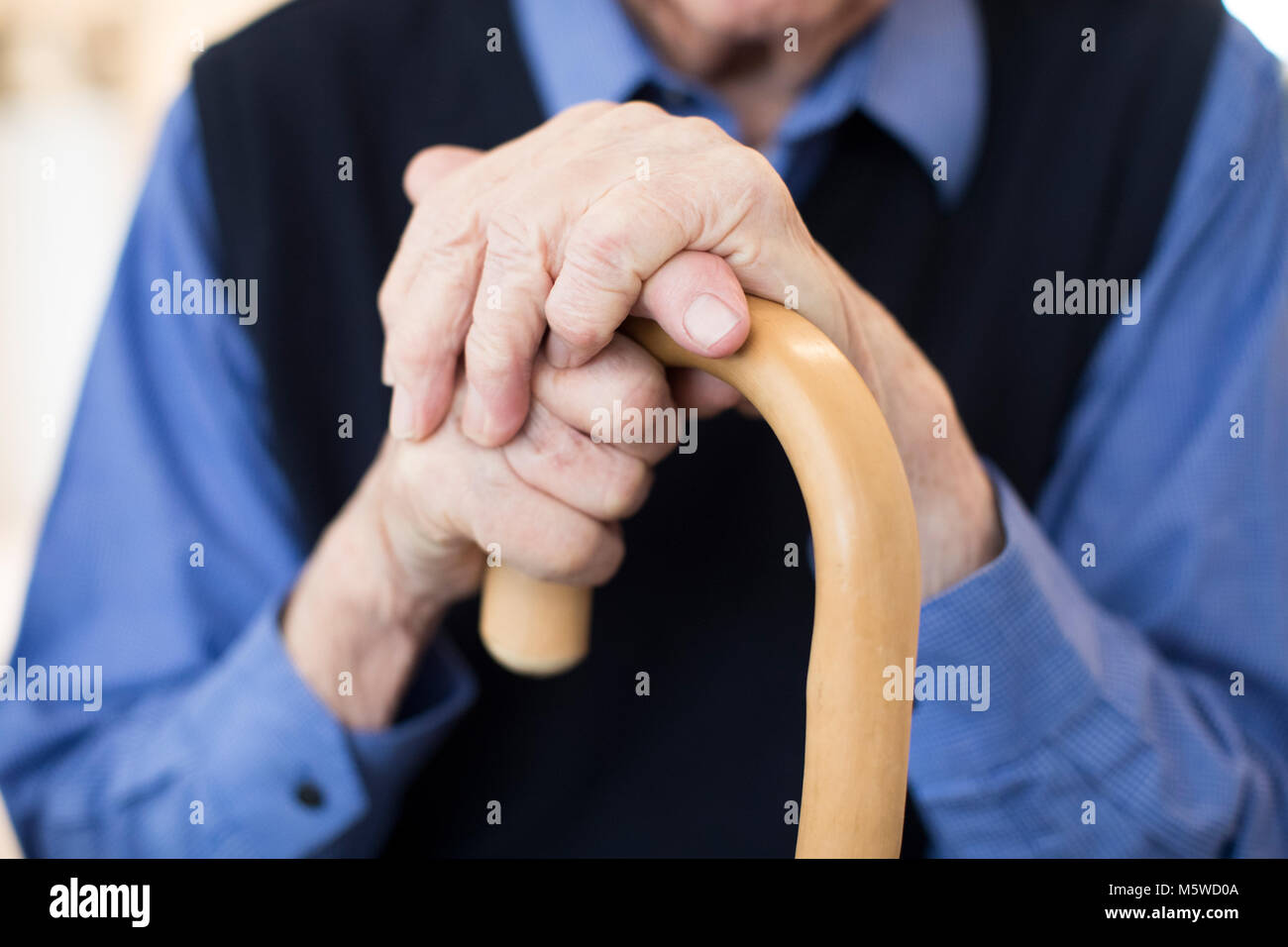Close Up Of Senior Man’s Hands Holding Walking Cane Stock Photo