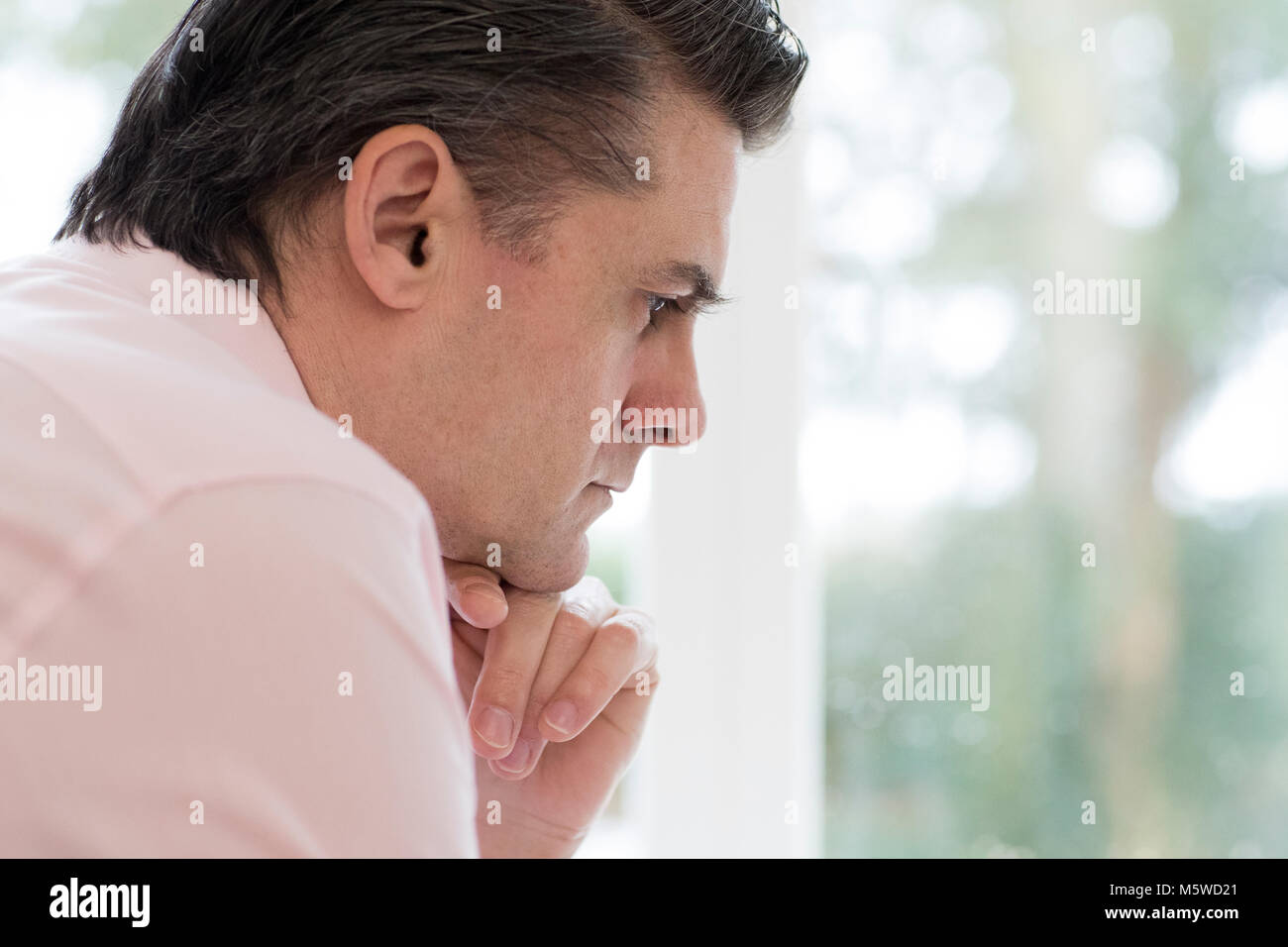 Profile View Of Worried Mature Man At Home Stock Photo