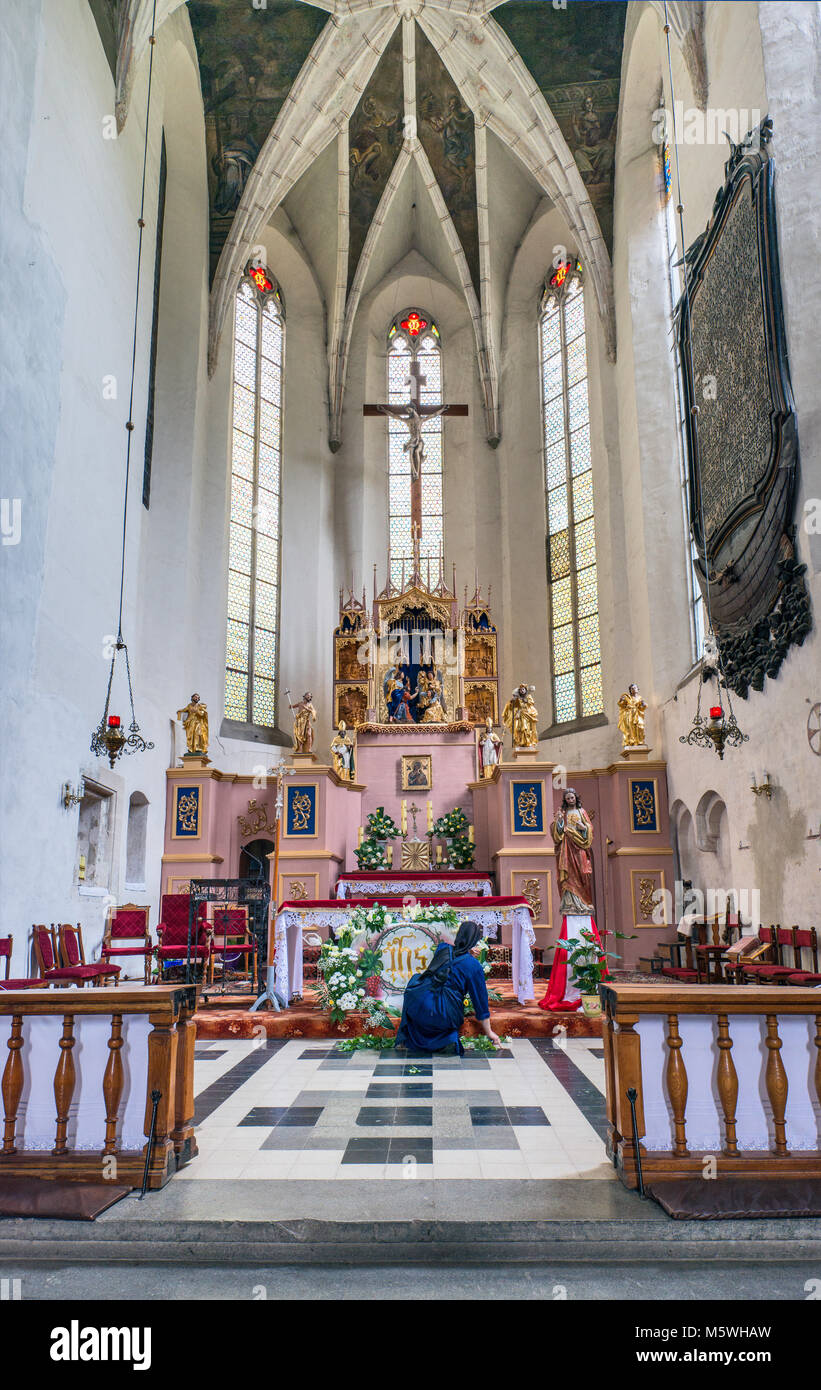 Interior of church with nun preparing presbytery for coming wedding, Polish Roman Catholic Church, 15th century, Drohobych, Lviv Oblast, Ukraine Stock Photo