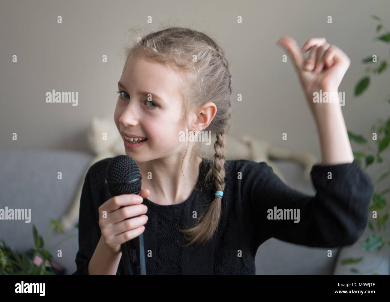 Cute little girl singing karaoke at home Stock Photo Alamy