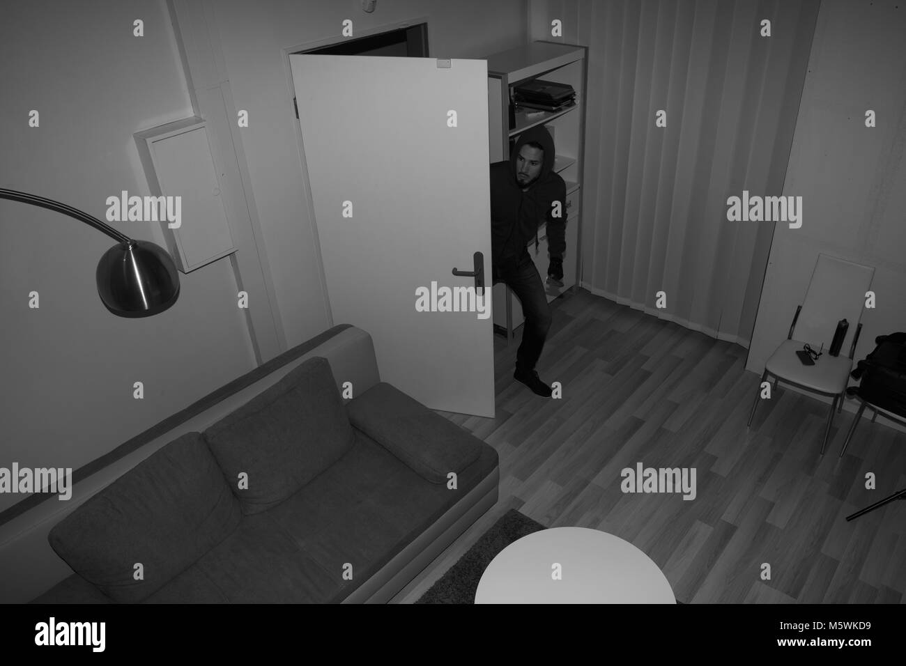 High Angle View Of A Robber Entering In Vacant House Stock Photo