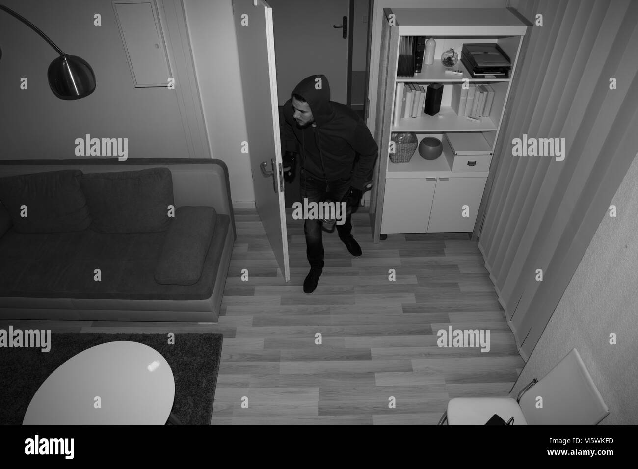 High Angle View Of A Robber Entering In Vacant House Stock Photo