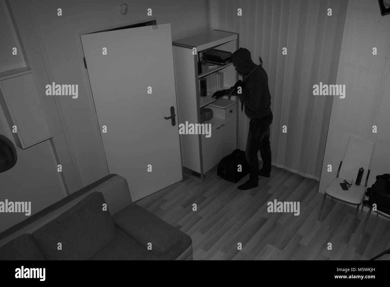 High Angle View Of A Robber Searching In Vacant House For Valuables Stock Photo