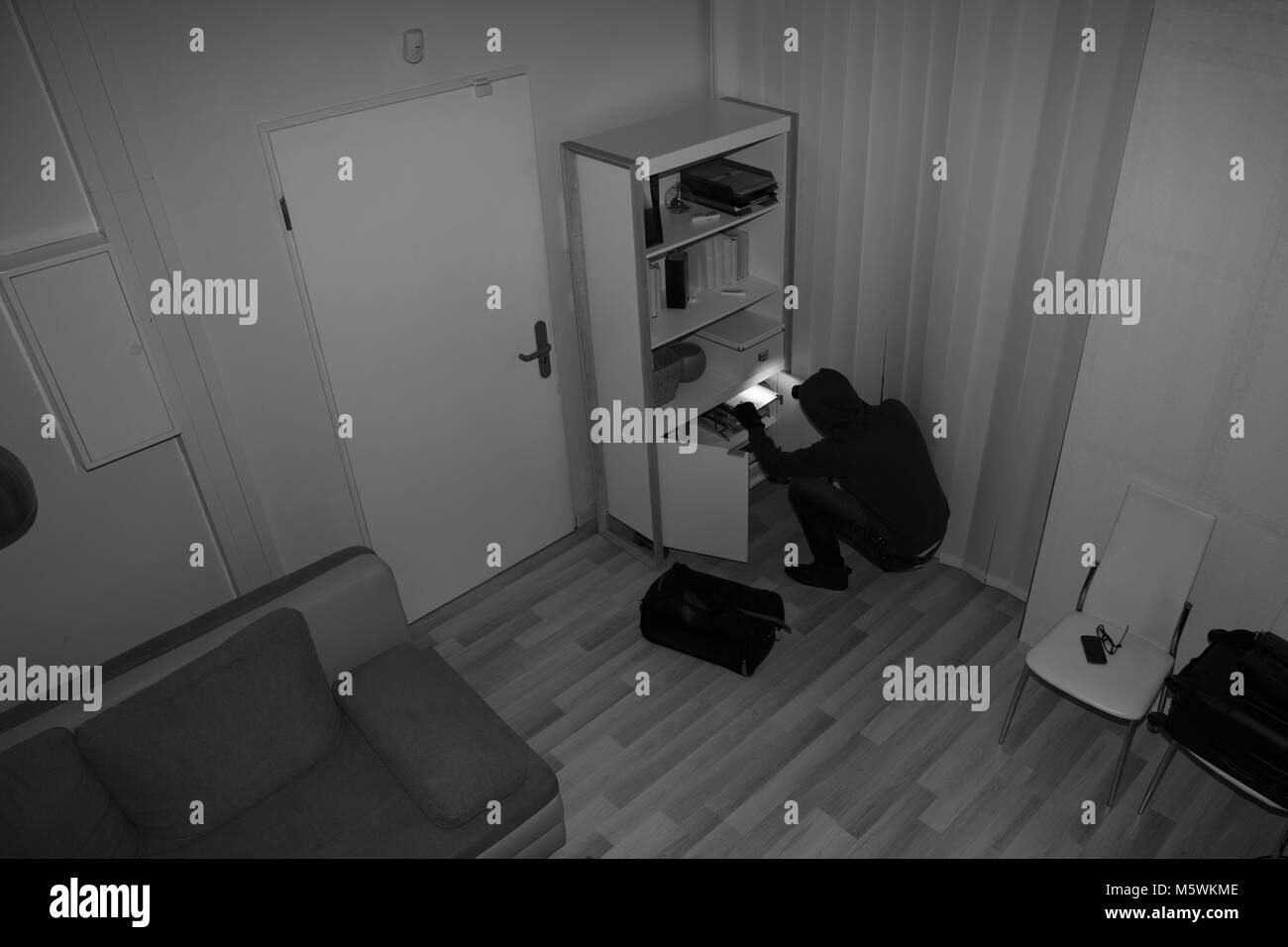 High Angle View Of A Robber Searching In Vacant House For Valuables Stock Photo