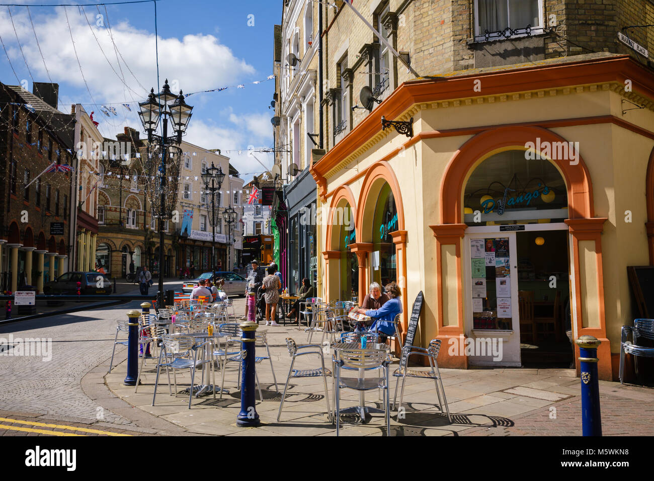 FOLKESTONE, UK - JUN 3, 2013: Customers dining at a sidewalk cafe on a sunny summer day Stock Photo