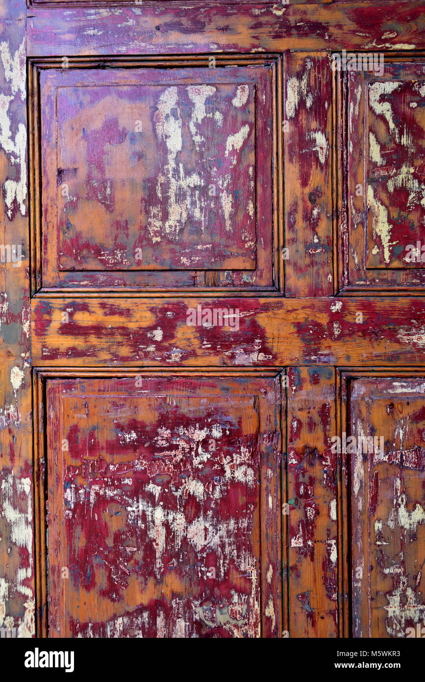 Old wooden door with paint partly stripped off Stock Photo