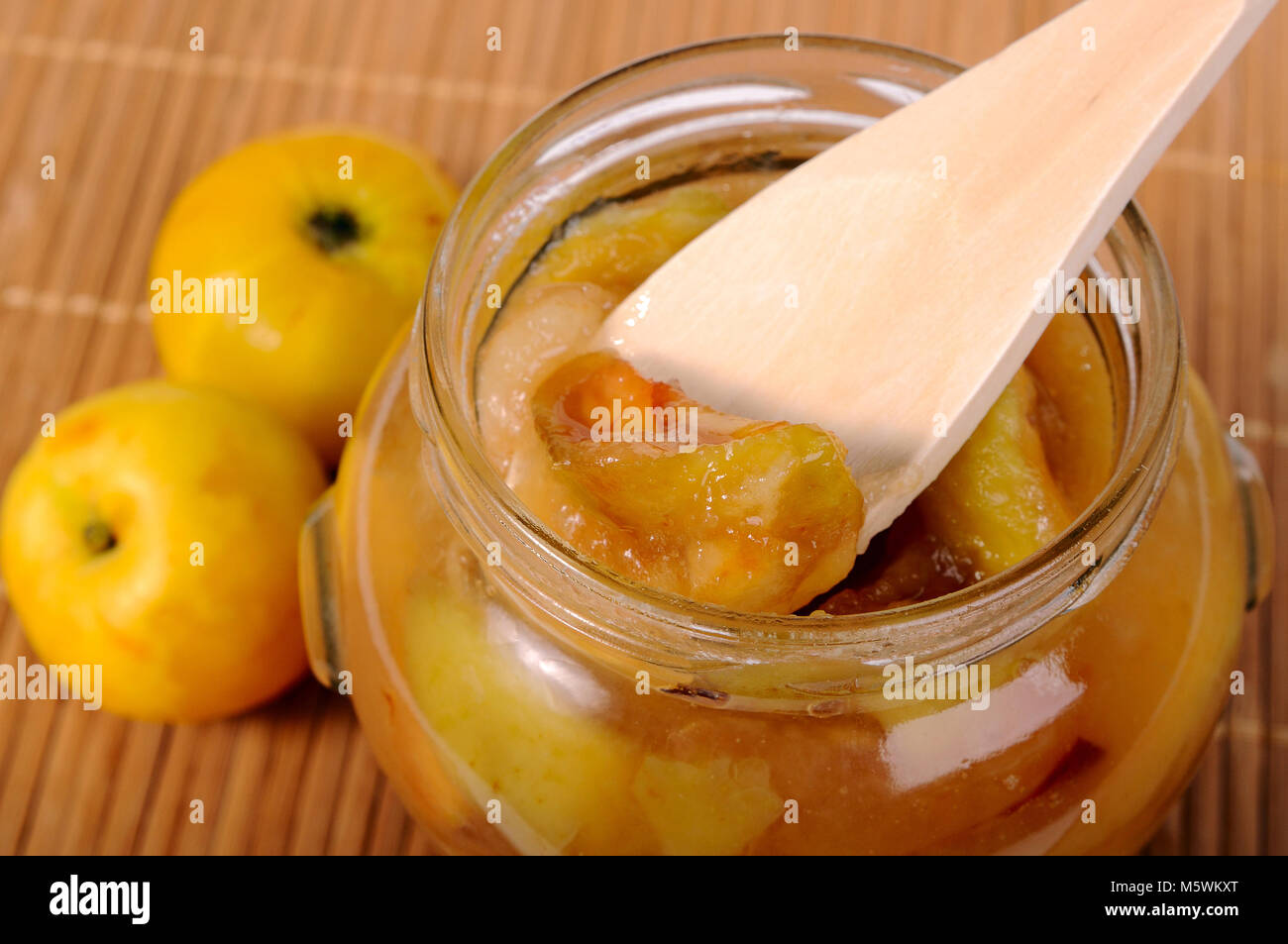 Wooden spoon in the jar of apple jam closeup Stock Photo