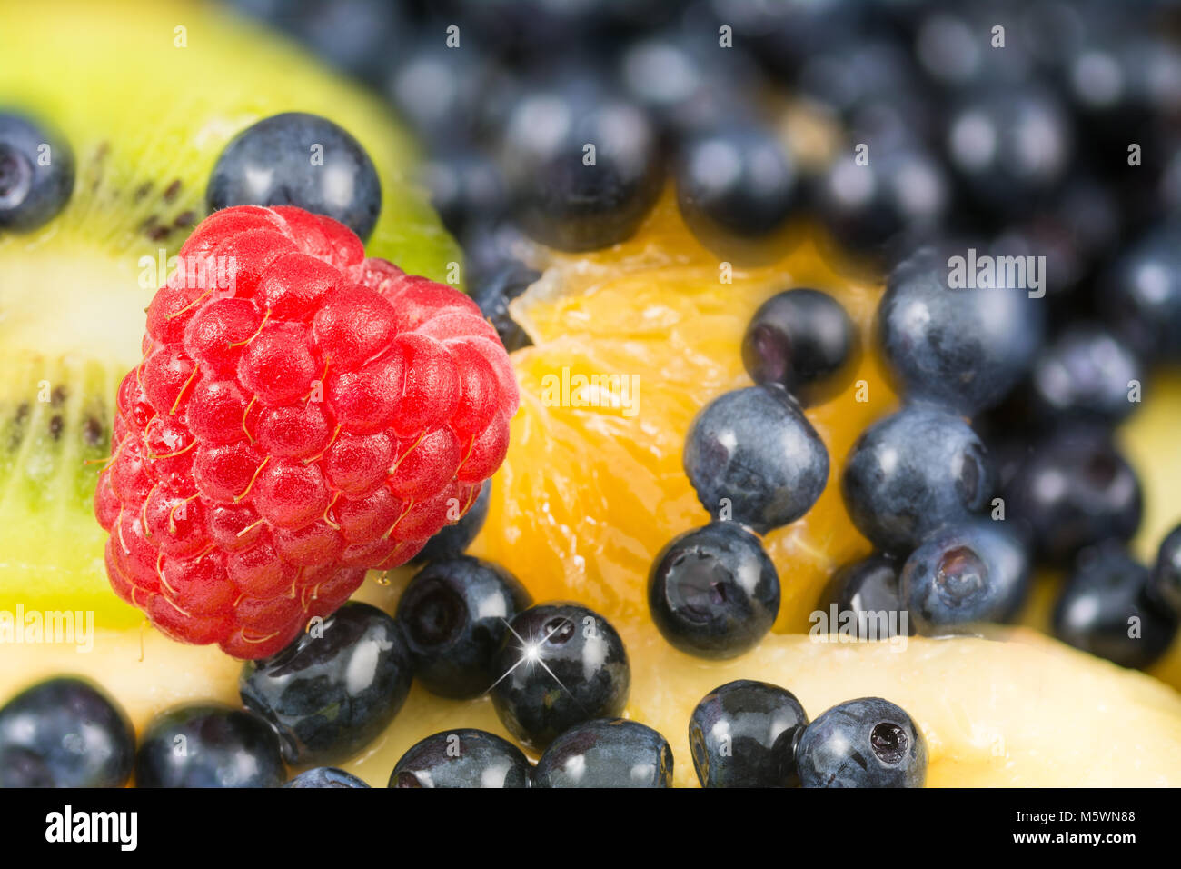 Close-up of beautiful red raspberry on a fruit salad background ...