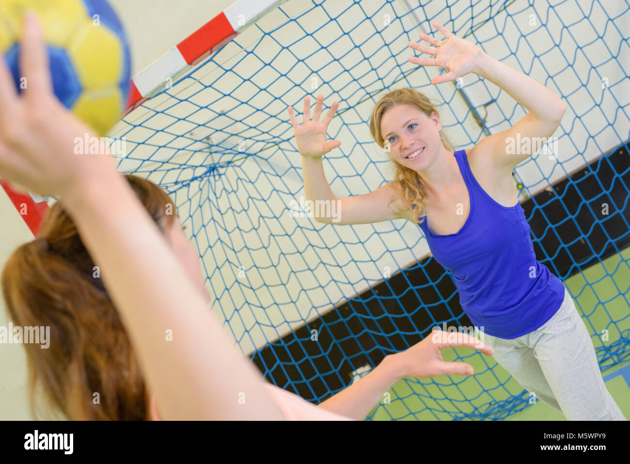 women playing game of handball defending goal Stock Photo