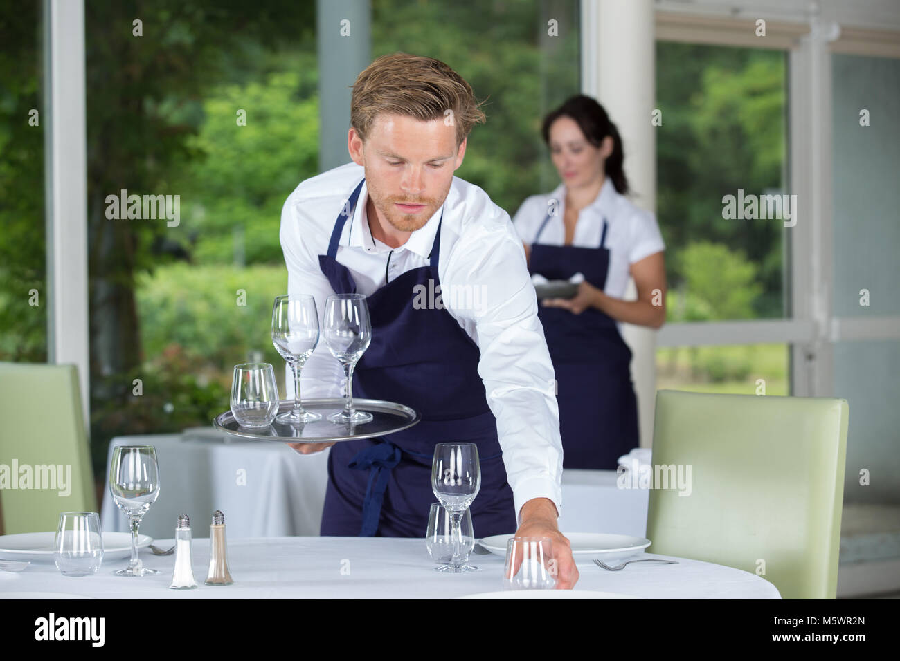 young worker table setting Stock Photo - Alamy