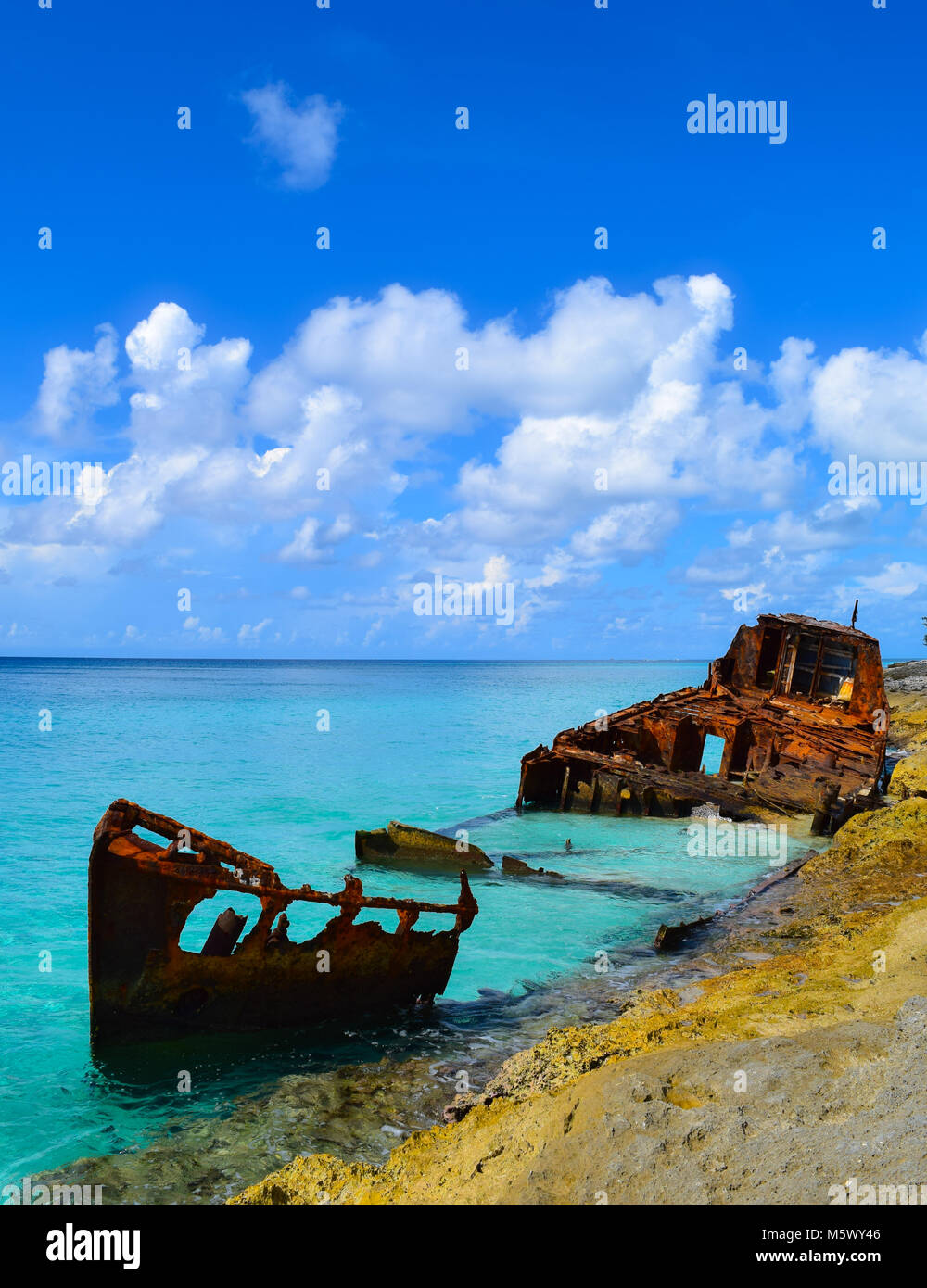 A shipwreck lies rusting in the crystal clear waters of the beautiful Caribbean island of North Bimini, Bahamas Stock Photo