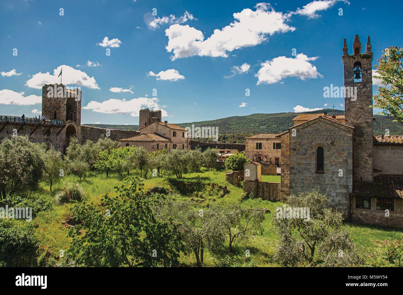 Buildings and trees from above the Monteriggioni hamlet walls. A medieval fortress, surrounded by stone walls, at the top of a hill, near Siena. Stock Photo