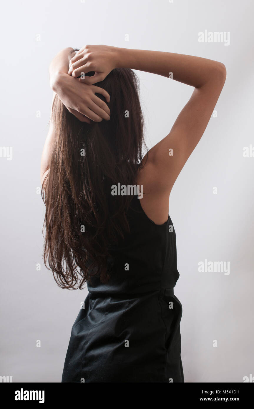 Rear view of a young woman hands on head Stock Photo - Alamy