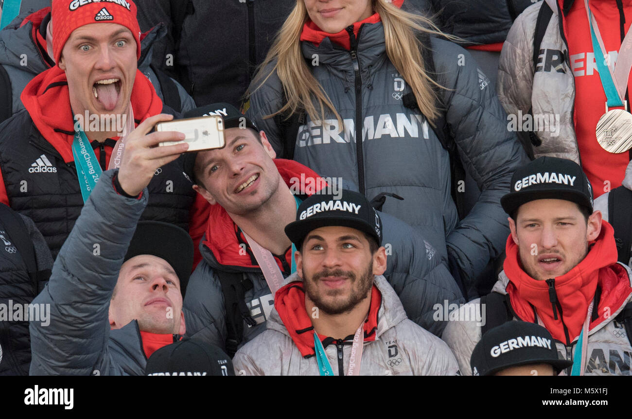 26 February 2018, Germany, Frankfurt am Main: German ice hockey players take selfies on the gangway after the landing of the Lufthansa aircraft LH713 with more than 150 other athletes, coaches and officials on board. Photo: Boris Roessler/dpa Stock Photo