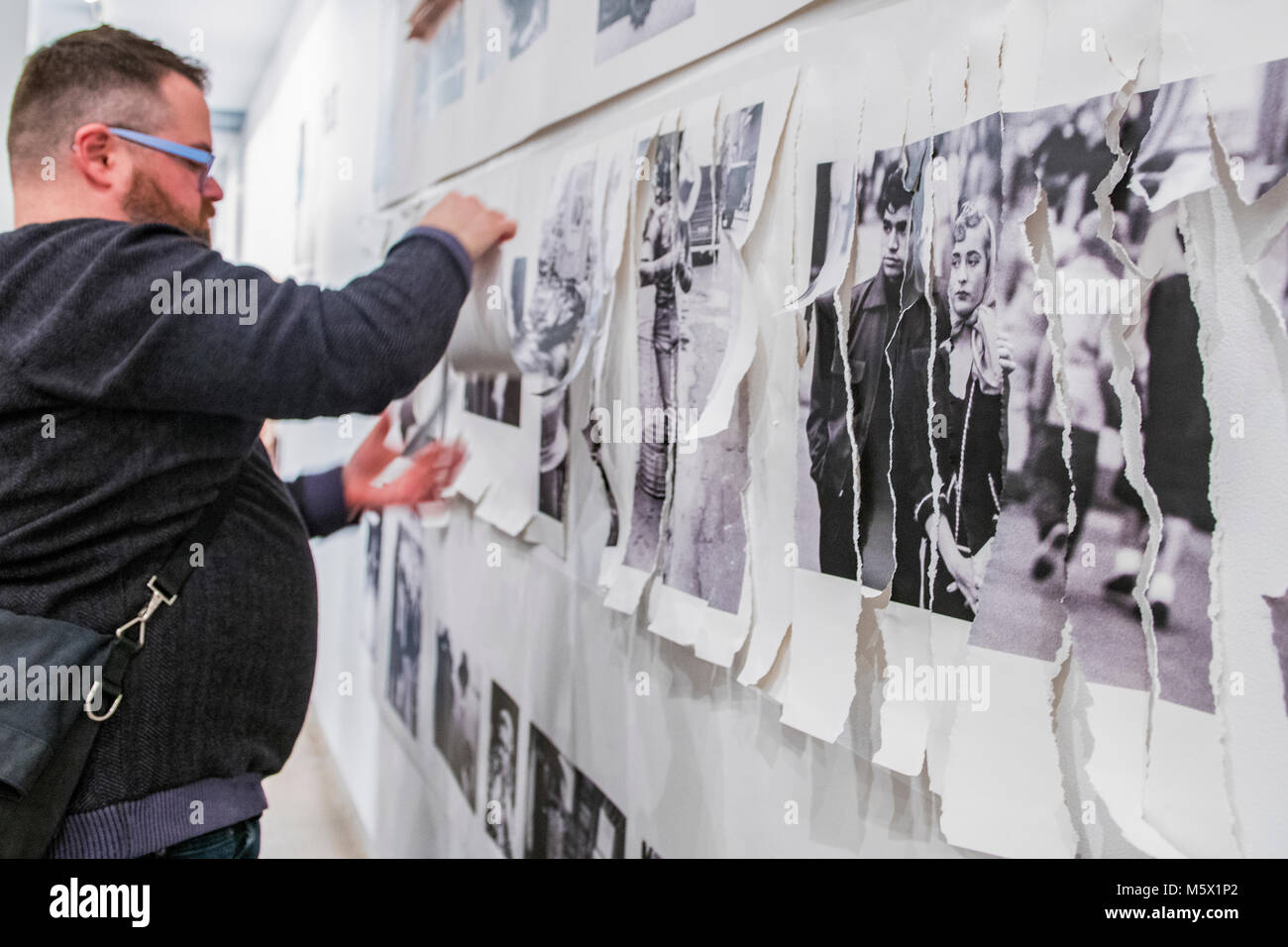Portland, Oregon, USA. 26 FEB, 2018. The photographer Robert Frank's work from his ground breaking book 'The Americans' hangs  defaced as a gallery goer shreds it at Blue Sky Gallery in Portland, Oregon, USA. The work was destroyed in a “Destruction Dance” performance defacing the photographs with ink and mutilation with scissors, knives and even ice skates  at the end of it’s run. The destruction was Frank's protest regarding today's greed in the global art market. Credit: Ken Hawkins/Alamy Live News Stock Photo