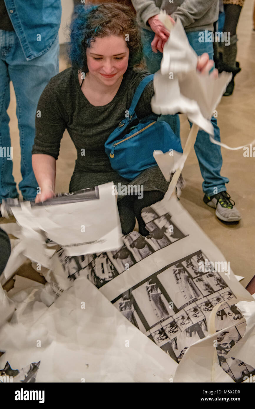 Portland, Oregon, USA. 26 FEB, 2018. Gallery goers help in shredding the photographer Robert Frank’s work printed on newsprint at Blue Sky Gallery in Portland, Oregon, USA. The work was destroyed in a “Destruction Dance” performance defacing the photographs with ink and mutilation with scissors, knives and even ice skates  at the end of it’s run. The destruction was Frank's protest regarding today's greed in the global art market. Credit: Ken Hawkins/Alamy Live News Stock Photo