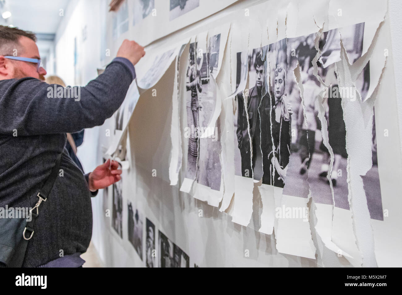 Portland, Oregon, USA. 26 FEB, 2018. The photographer Robert Frank's work from his ground breaking book 'The Americans' hangs  defaced as a gallery goer shreds it at Blue Sky Gallery in Portland, Oregon, USA. The work was destroyed in a “Destruction Dance” performance defacing the photographs with ink and mutilation with scissors, knives and even ice skates  at the end of it’s run. The destruction was Frank's protest regarding today's greed in the global art market. Credit: Ken Hawkins/Alamy Live News Stock Photo