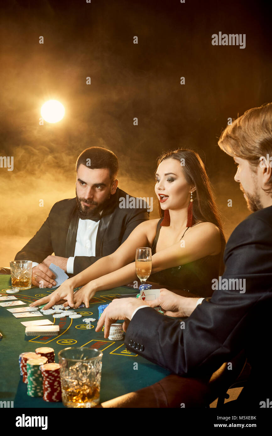Group of young rich people playing poker in the casino