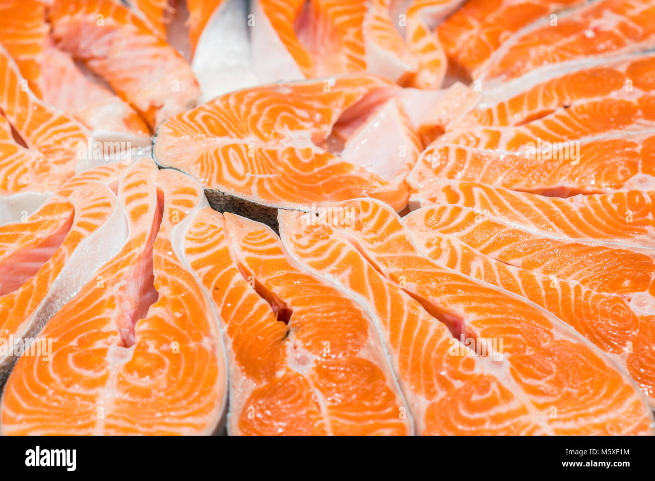 Salmon Red Fish Steak at the fish market. Raw fresh steaks of Salmon fish as background. Large Pile of salmon steak with ice. Big organic steaks of sa Stock Photo