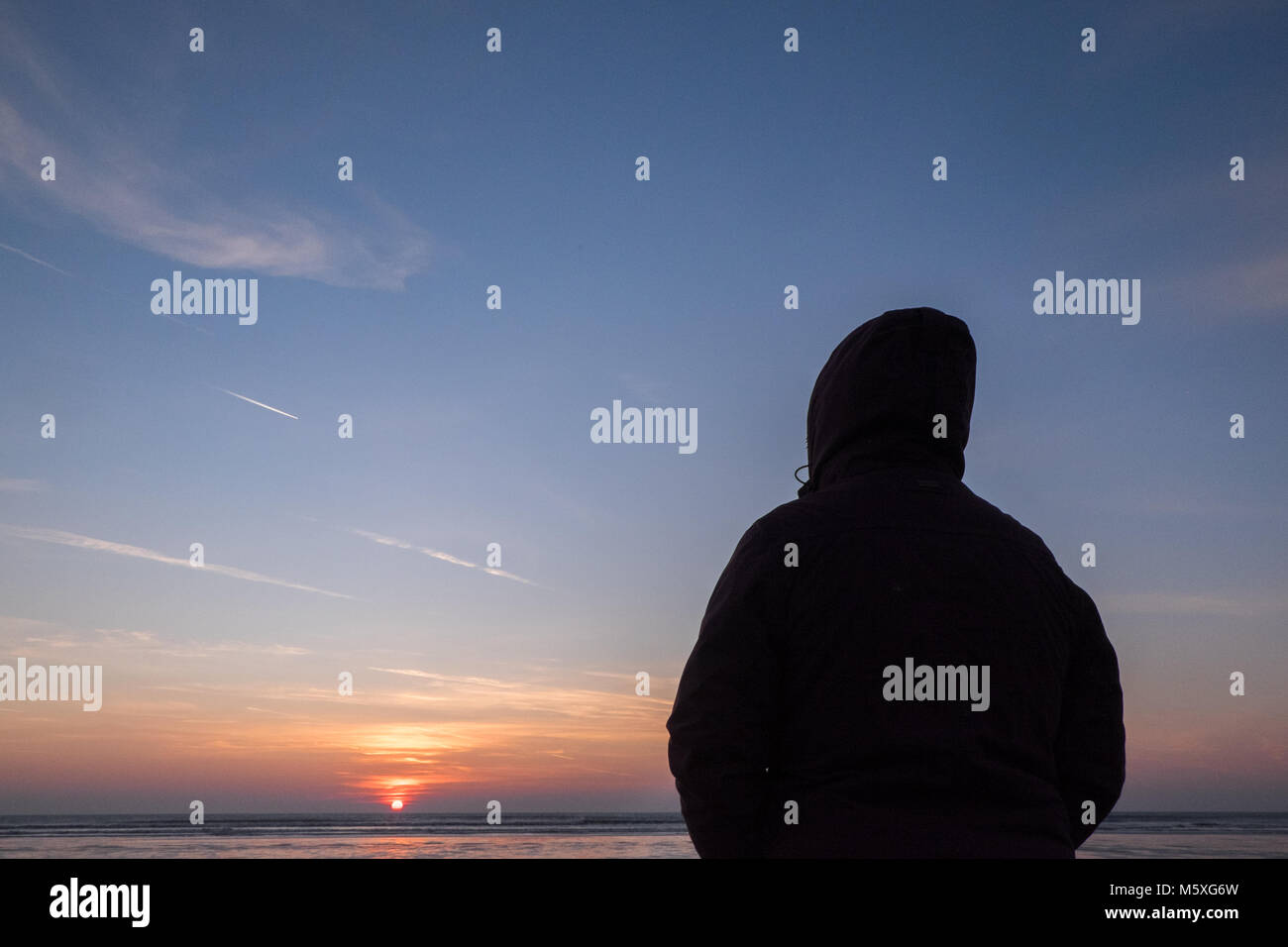 Cold,winter,winters,day,dressed,in,warm,clothing,watching,watch,sun,sunset,Ynyslas,Beach,Ceredigion,Wales,UK,U.K., Stock Photo