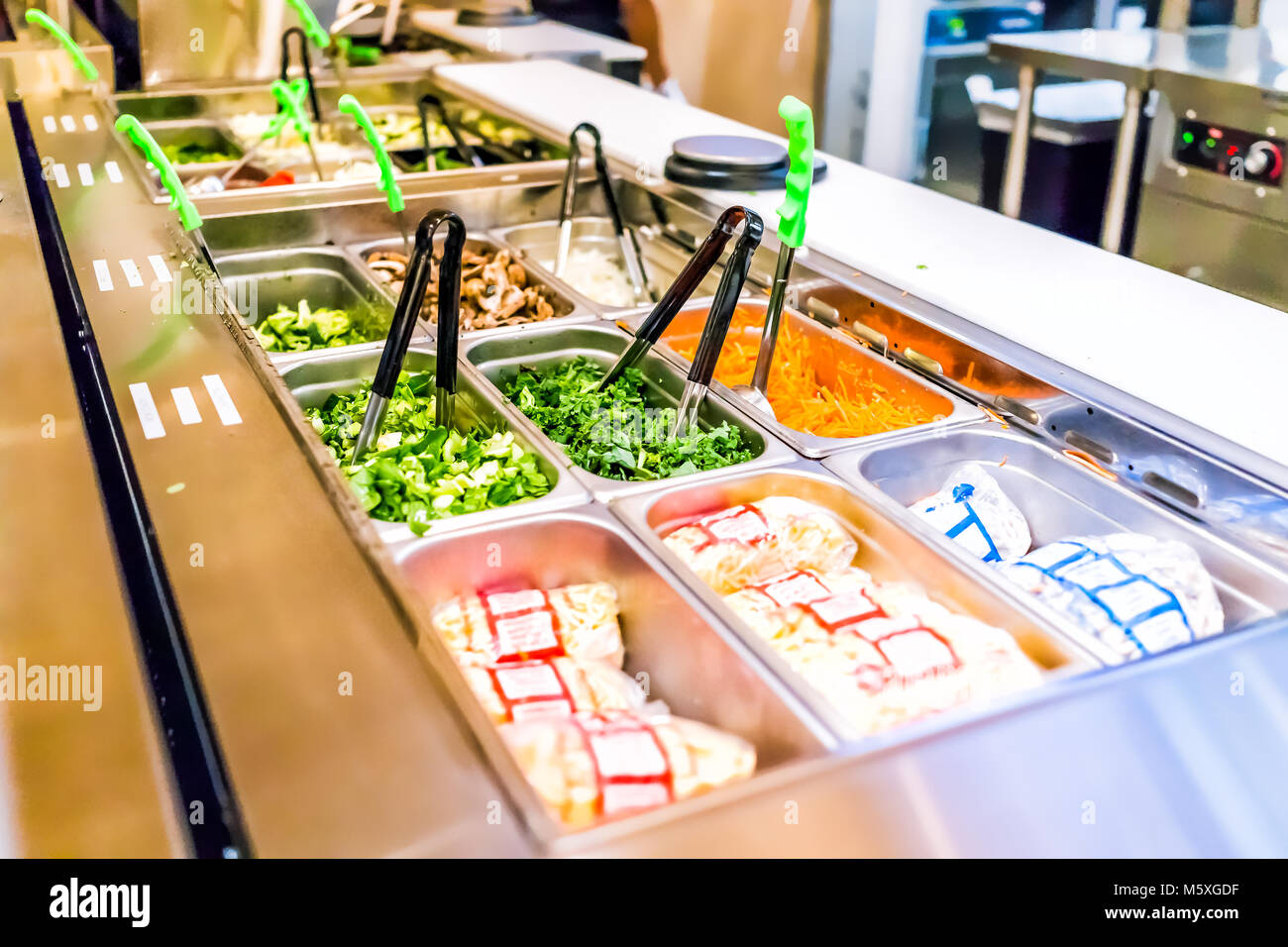 Restaurant buffet serving counter with salad vegetables, celery, kale, carrots, sprouts Stock Photo