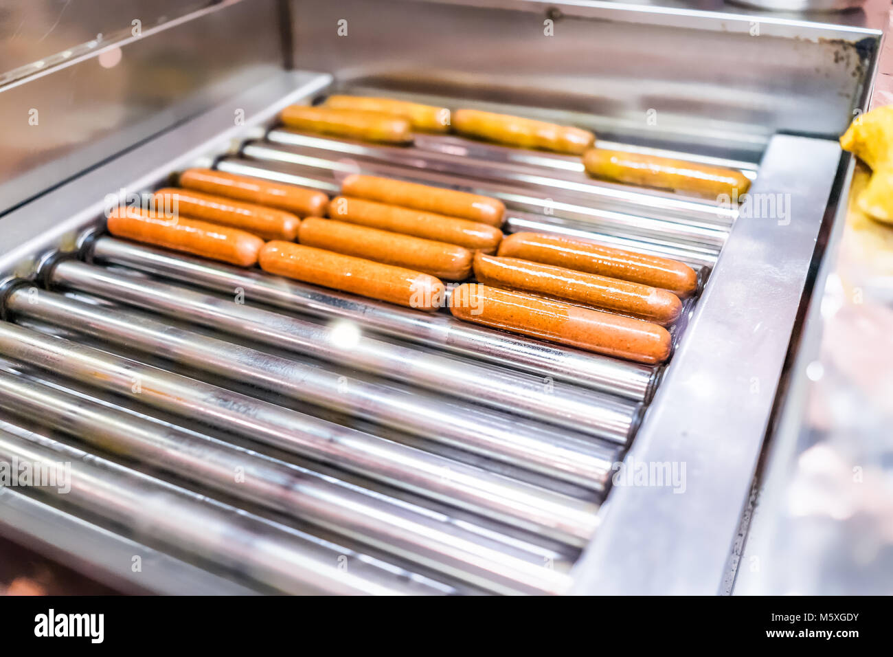 Hot dog sausages greasy grilling turning in commercial ...