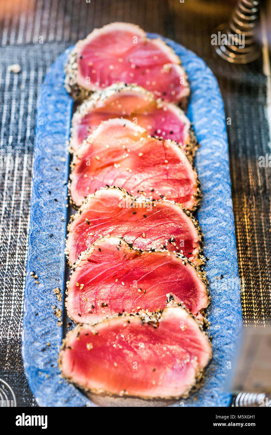 Seared raw ahi tuna rare steaks with black pepper crust on display in