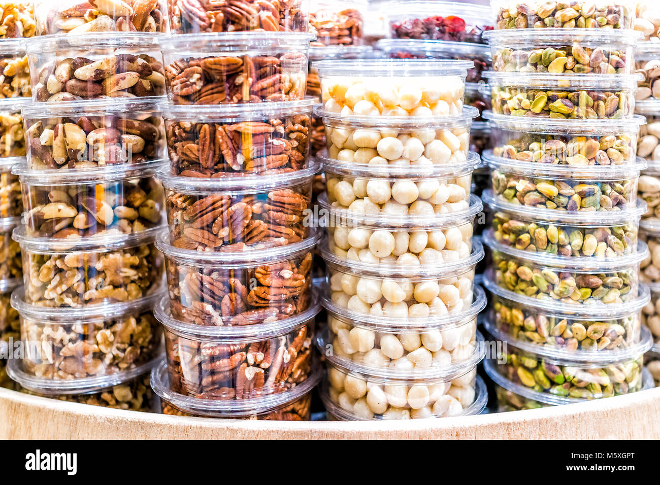 Many packaged seeds, nuts, dried in plastic containers on display on store shop shelves