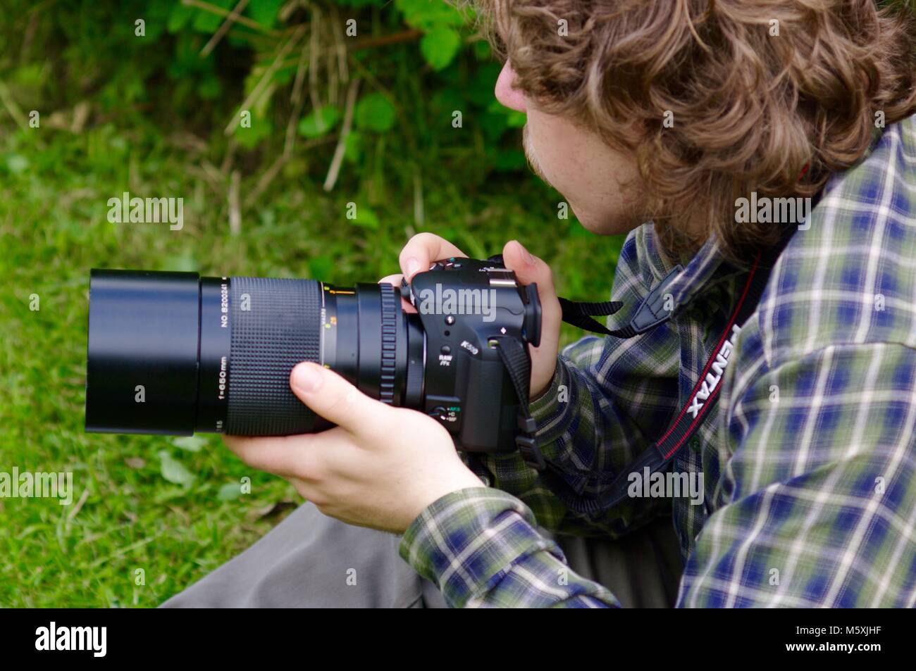 Teenaged Nature Photographer with Long Blonde Hair in Green Country