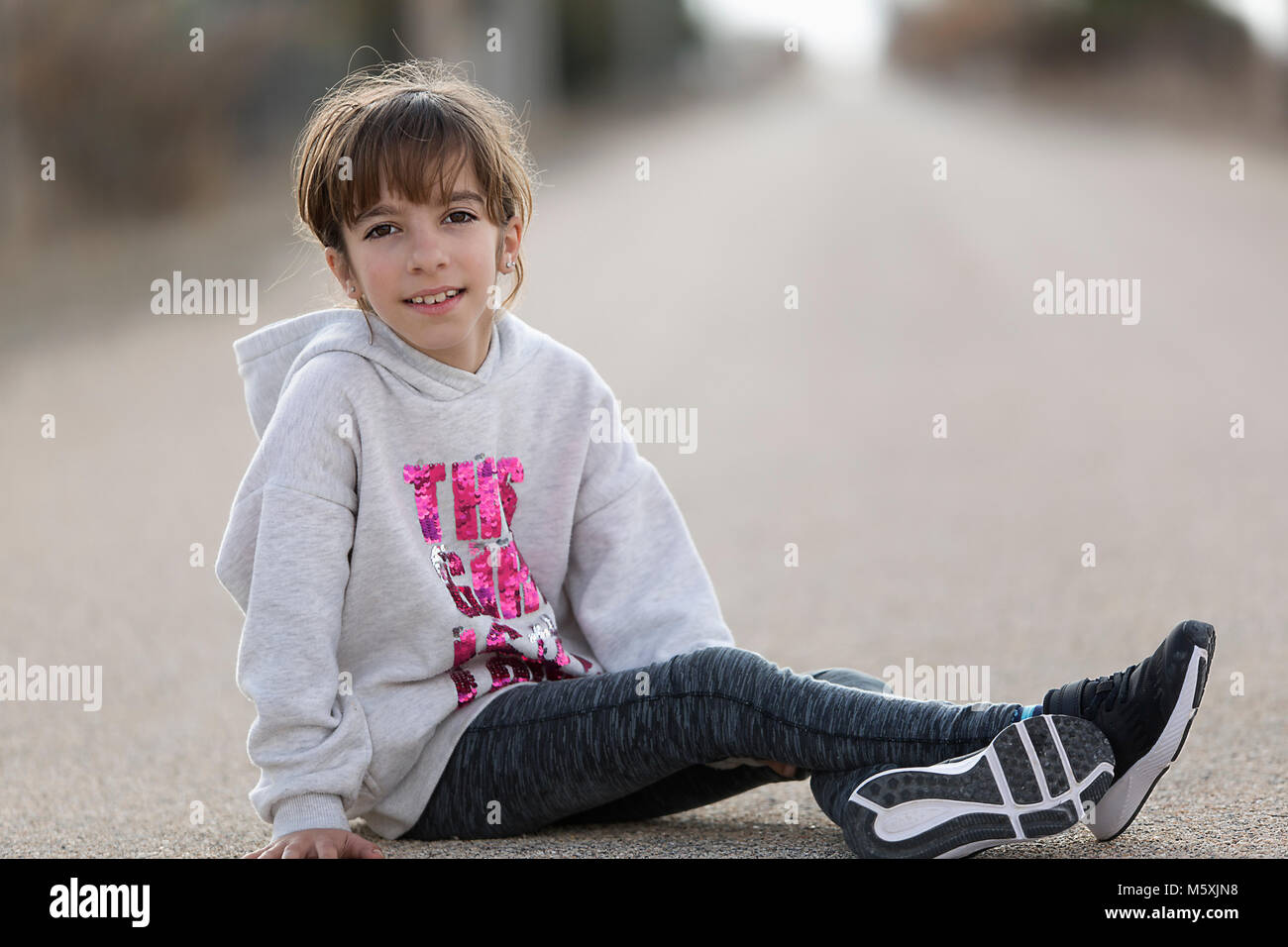10-year-old girl sitting on the floor of a car looking at the camera. Horizontal shot with natural light Stock Photo
